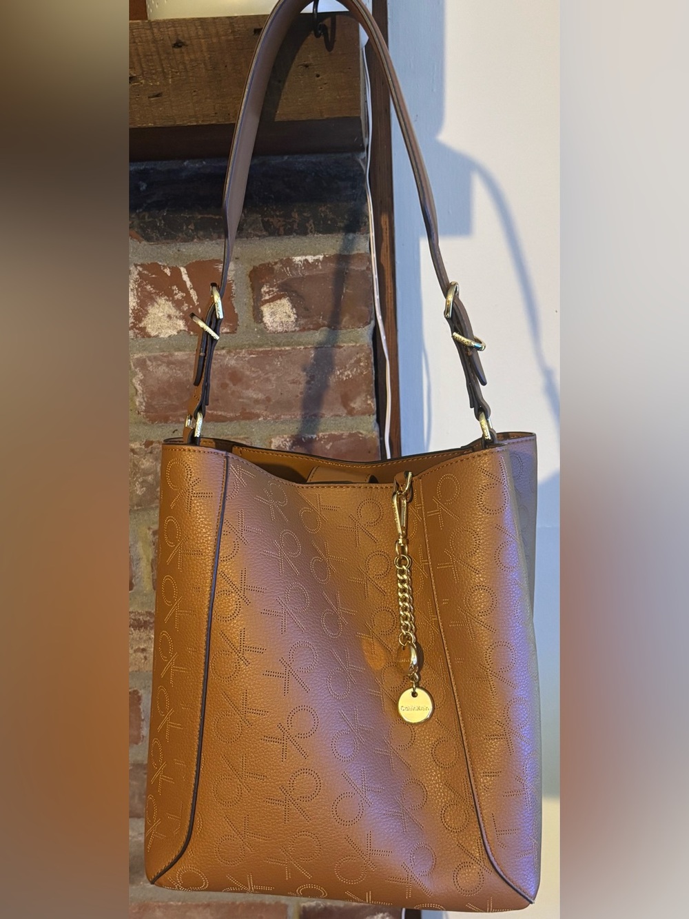 Calvin Klein perforated Logo over the shoulder bag with Gold Charms.